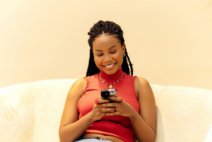 Woman smiling at her phone after her loan funds arrive