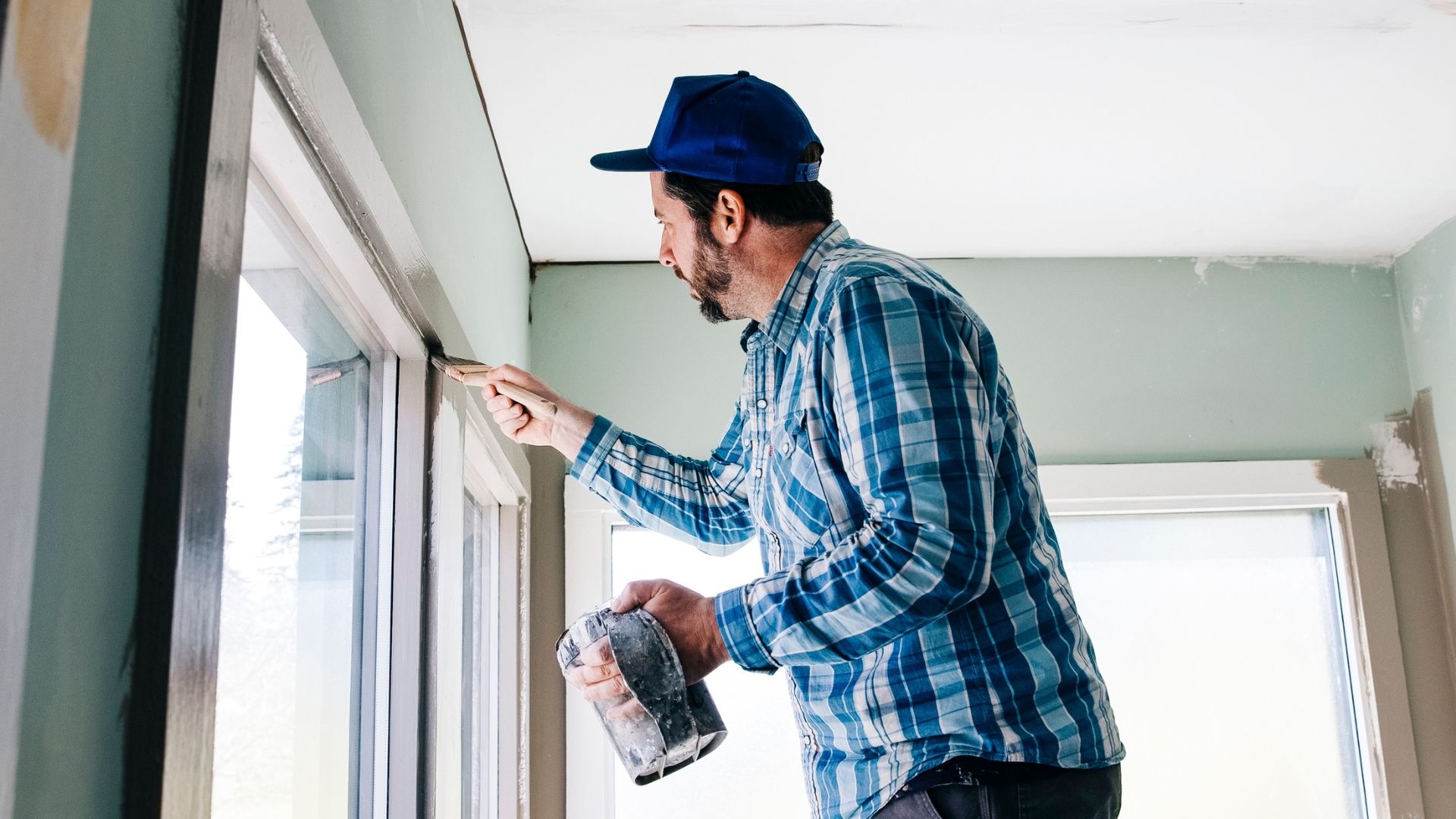 Man applying PPG Paints with brush onto window frame