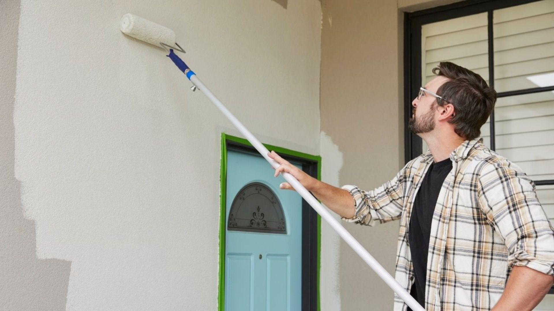 Image of man applying Taubmans exterior paint on wall that won the Canstar most overall satisfied customer in 2025