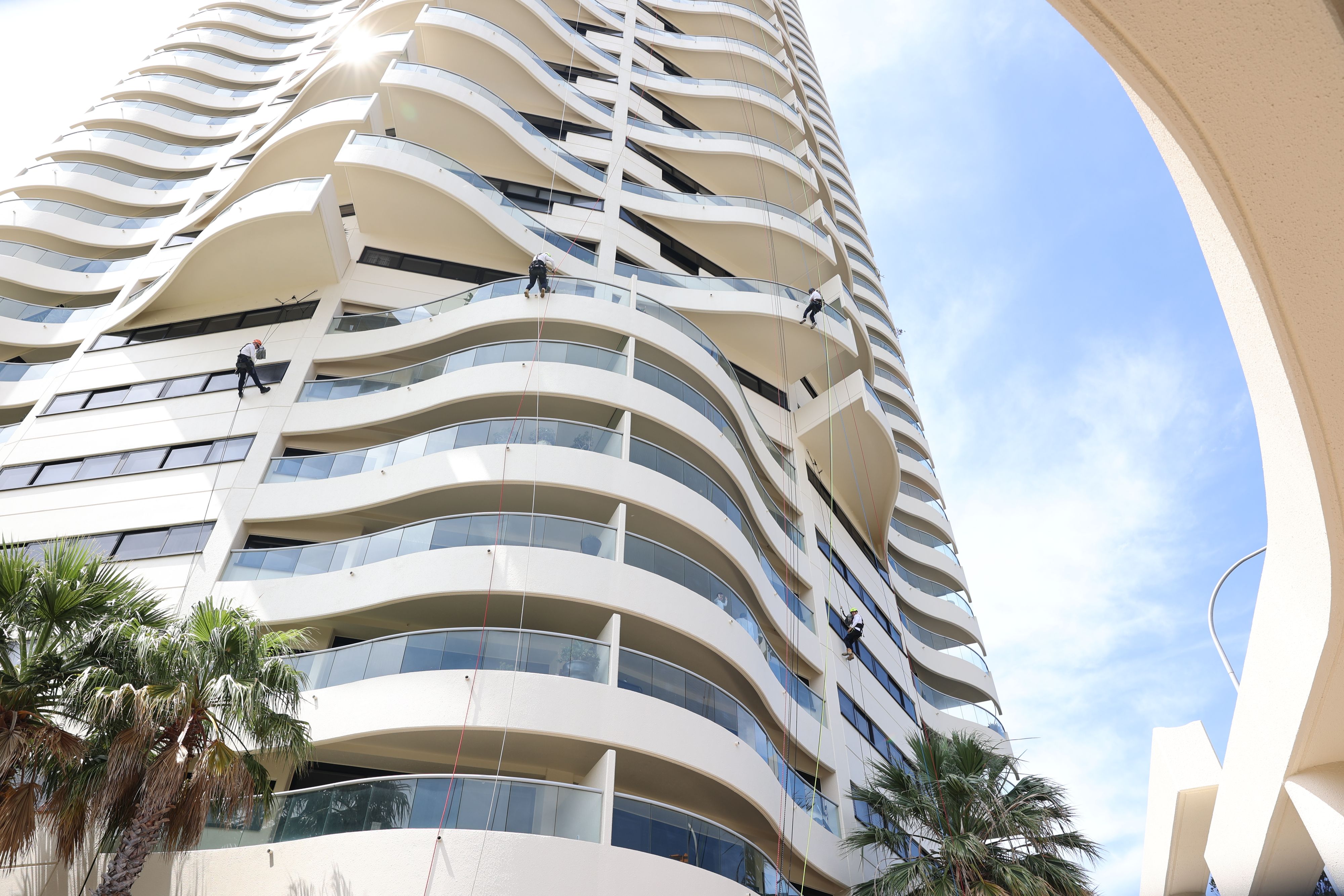 Painters abseiling to paint the facade of 43-storey apartment building.